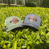Two caps with logos on a grassy background