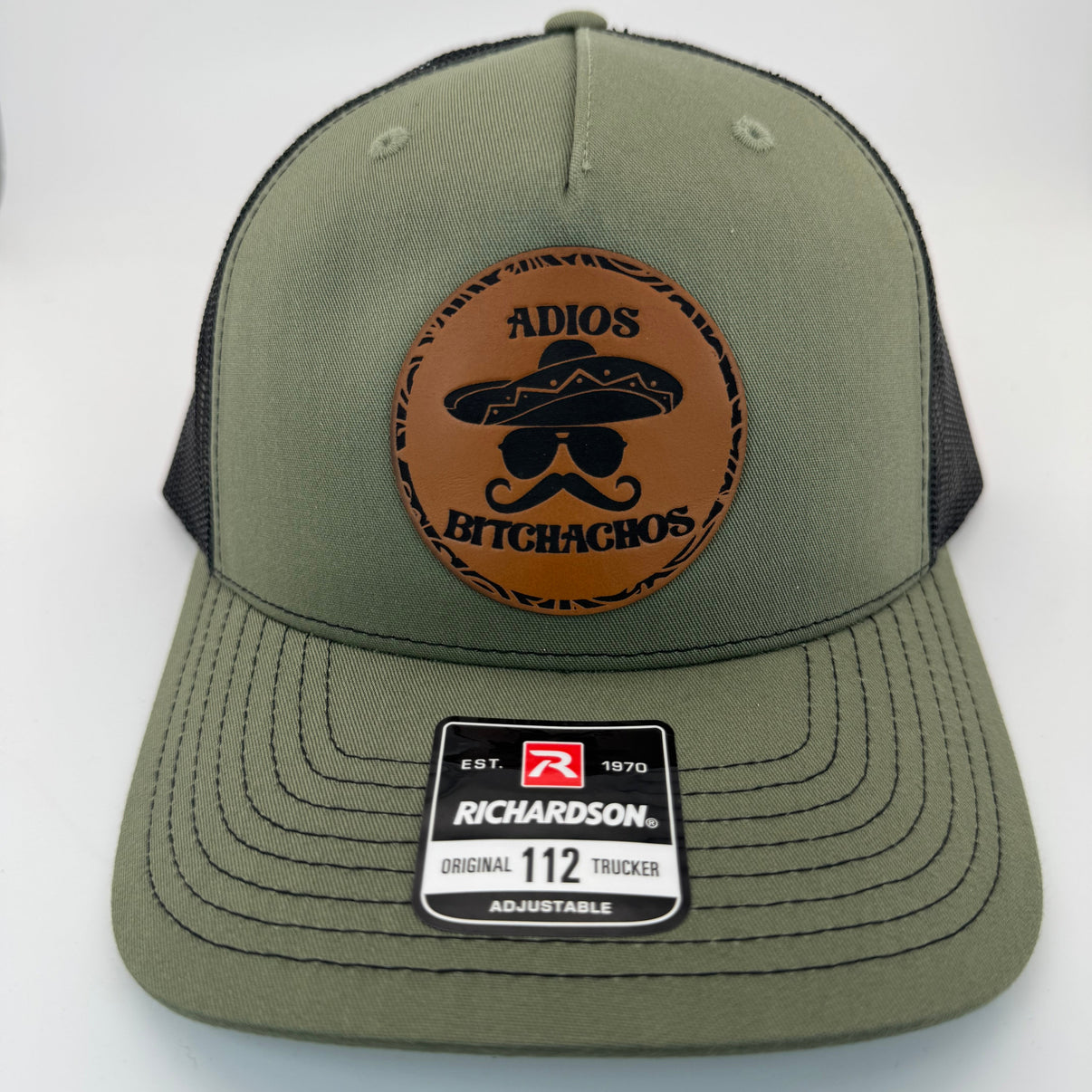 Richardson 112FP trucker hat with custom laser engraved leather patch featuring Adios Bitchachos logo, Loden Green and Black Mesh Color scheme