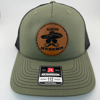 Richardson 112FP trucker hat with custom laser engraved leather patch featuring Adios Bitchachos logo, Loden Green and Black Mesh Color scheme