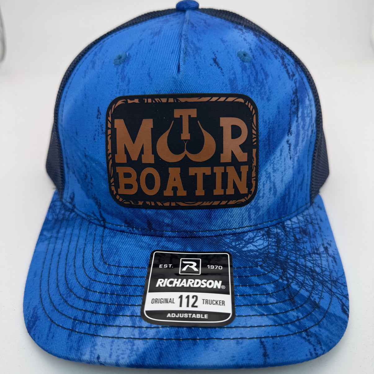 Richardson 112PFP trucker hat with custom laser engraved leather patch featuring Motor Boatin logo, Realtree Fishing and Navy color scheme