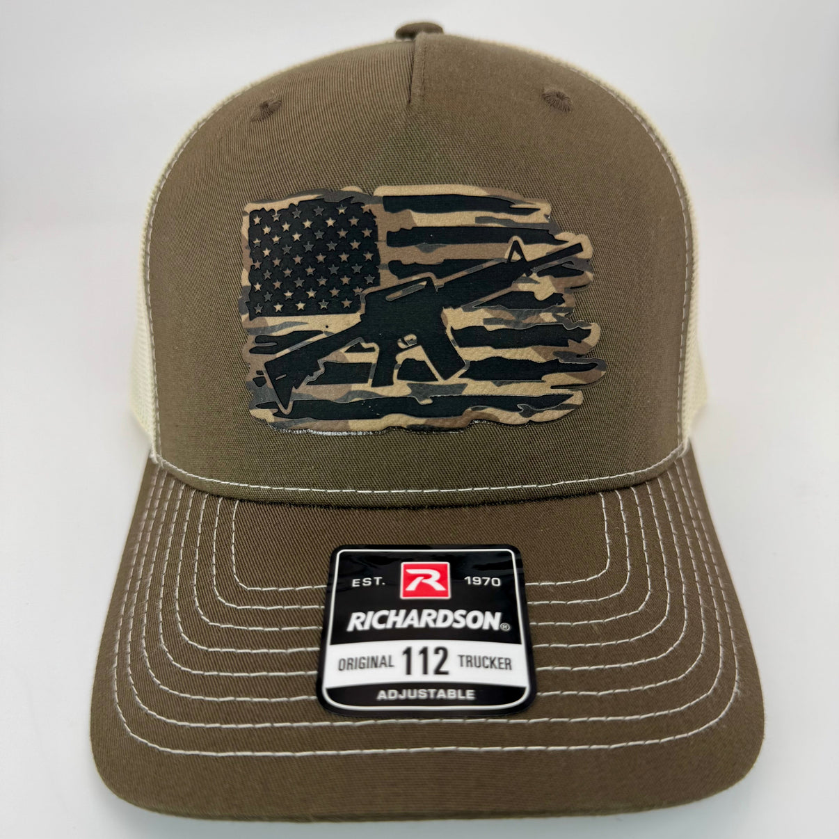 Richardson 112FP trucker hat featuring a patch with a USA flag and M16 rifle in the center, classic mesh back and adjustable snapback closure.