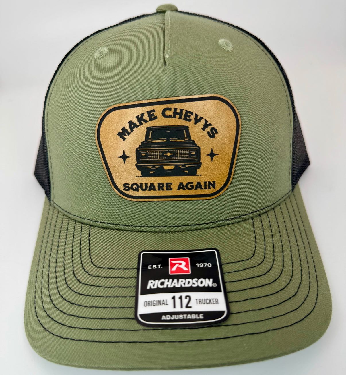 Richardson 112FP patch hat in loden green with black mesh, featuring a laser-engraved leather patch reading "MAKE CHEVY SQUARE AGAIN" on the front panel.