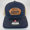 Richardson 112 patch hat in navy with khaki mesh, featuring a laser-engraved leather patch reading "Hoochie Daddy" on the front panel.