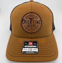 Richardson 112 trucker hat with custom laser engraved leather patch featuring Overtime Hours, Working All Day For Bullshit Pay logo, Carmel and Black color scheme