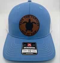Richardson 112 trucker hat with custom laser engraved leather patch featuring Save the Turtles, Hit it Raw logo, Columbia Blue and White color scheme
